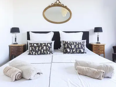 a large white bed with two pillows and a mirror at Holiday Home Les Genêts by Interhome in Nice