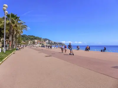 a group of people walking down a sidewalk on the beach at Holiday Home Les Genêts by Interhome in Nice