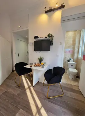 a room with two chairs and a table and a toilet at Cozy studio, balcony & AC, Heart of Nice in Nice