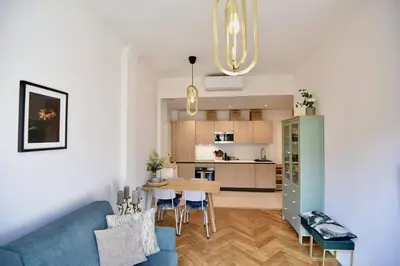 a living room with a blue couch and a kitchen at Nice Signature The Port in Nice