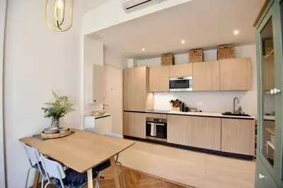 a kitchen with a wooden table in a room at Nice Signature The Port in Nice