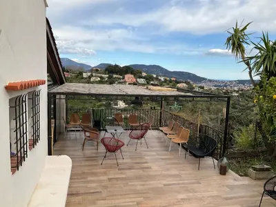 a patio with chairs and a table on a balcony at Maison avec vue mer et jacuzzi à 15 mn du centre in Nice