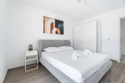 a bedroom with two beds and a table at Appartement Colombier - Welkeys in Saint-Laurent-du-Var