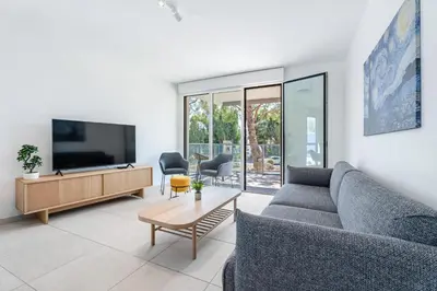 a living room with a couch and a tv at Appartement Colombier - Welkeys in Saint-Laurent-du-Var