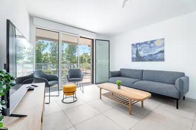 a living room with a couch and chairs and a table at Appartement Colombier - Welkeys in Saint-Laurent-du-Var