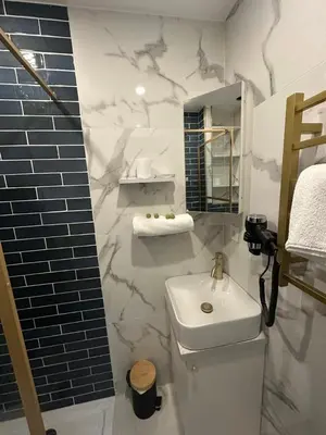a white bathroom with a sink and a mirror at MASSENA 42 in Nice