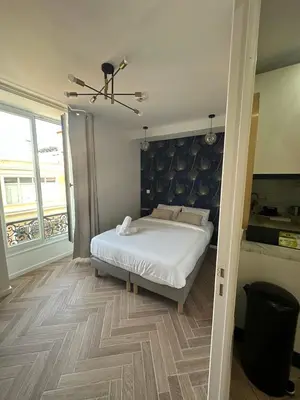a bedroom with a white bed and a large window at MASSENA 42 in Nice
