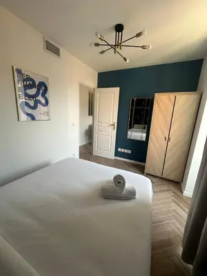 a bedroom with a large white bed and a closet at MASSENA 42 in Nice