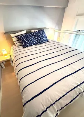 a large bed with blue and white pillows on it at Beautiful Carré d'Or studio in Nice
