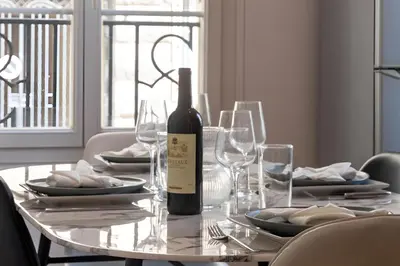 a bottle of wine sitting on a table with glasses at Azur elegance AIR CONDITIONING Beach 8 min Sleeps 6 in Nice