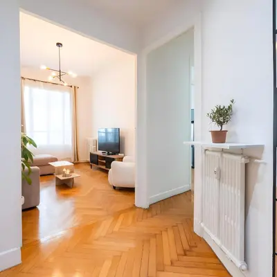 a living room with white walls and wooden floors at Azur elegance AIR CONDITIONING Beach 8 min Sleeps 6 in Nice