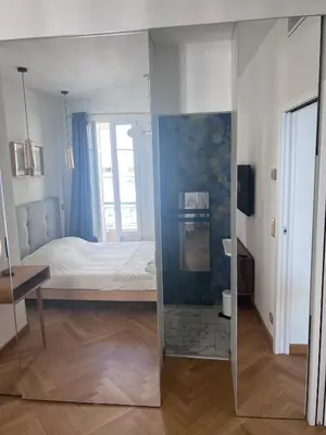 a bedroom with a bed and a mirror at Appartement Prestige sur la Promenade des Anglais in Nice