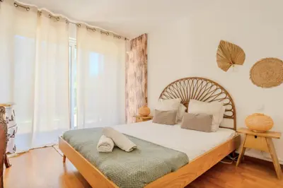 a bedroom with a large bed and a window at Charming 80m for 6 people with garden in Cagnes-sur-Mer