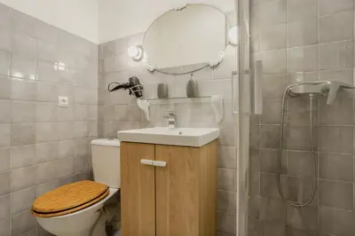 a bathroom with a toilet and a sink and a mirror at Charming 80m for 6 people with garden in Cagnes-sur-Mer