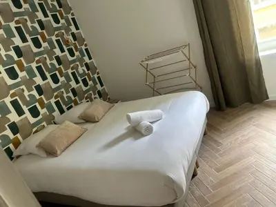 a bed with a white towel on it in a room at MOON 26 - Appartement Nice 6P in Nice