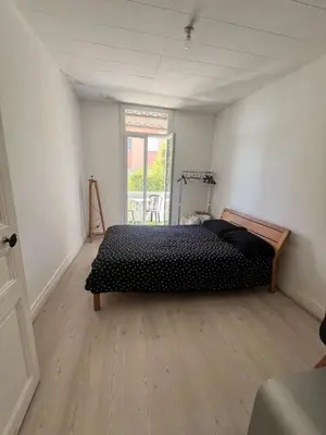 a bedroom with a bed in the corner of a room at Charmant et cosy 3pcs in Nice