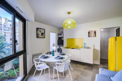 a kitchen and dining room with a table and chairs at Résidence Grand Hôtel Nice in Nice