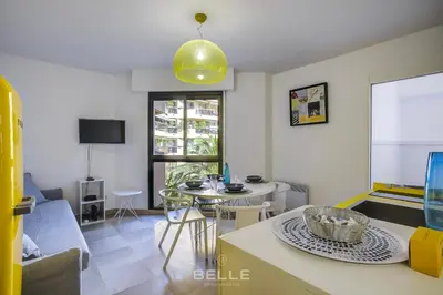 a living room with a table and a dining room at Résidence Grand Hôtel Nice in Nice