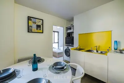 a kitchen with a table and a sink and a microwave at Résidence Grand Hôtel Nice in Nice