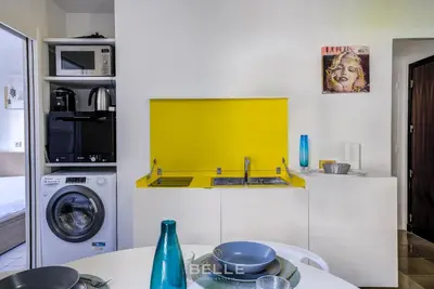 a kitchen with a sink and a washing machine at Résidence Grand Hôtel Nice in Nice
