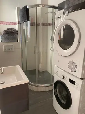 a washer and dryer in a bathroom with a sink at cosy appartement in Nice