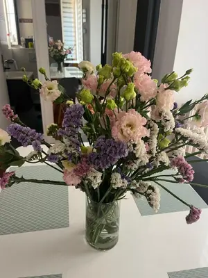 a vase filled with pink and purple flowers on a table at cosy appartement in Nice