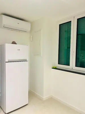 a white kitchen with a refrigerator and a window at Palais Clerissy - Appartement 2 à 4 personnes centre ville Nice in Nice