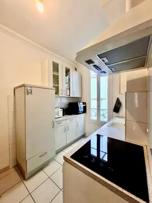 a kitchen with a white refrigerator and a counter top at 2 Pièces en étage au Centre-ville de Nice in Nice