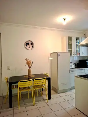 a kitchen with a table and chairs and a refrigerator at 2 Pièces en étage au Centre-ville de Nice in Nice