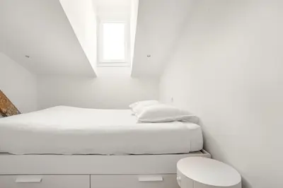 a white bedroom with a bed and a window at Cosy 2 pieces au Coeur du Centre Ville in Nice