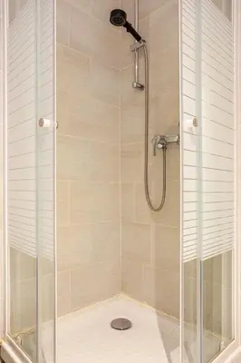 a shower stall with a glass door with a shower at Cosy 2 pieces au Coeur du Centre Ville in Nice