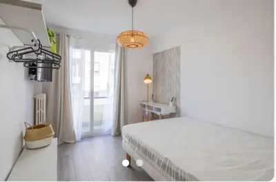 a white bedroom with a bed and a window at chambre privé chez l'habitant avec salle de bain privative in Nice