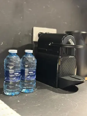 two bottles of water sitting next to a camera at Le Notre Dame in Nice
