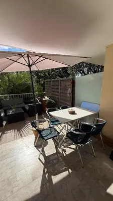 a table and chairs with an umbrella on a patio at Modern apartment with sunny terrace in Nice