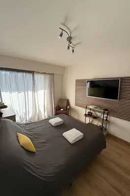 a bedroom with a large bed with a flat screen tv at Modern apartment with sunny terrace in Nice