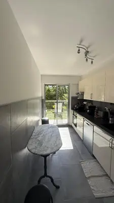 a kitchen with a stool and a table in it at Modern apartment with sunny terrace in Nice