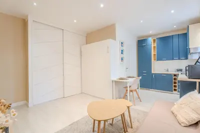 a living room with blue cabinets and a table and chairs at Fontaine de la Ville in Nice