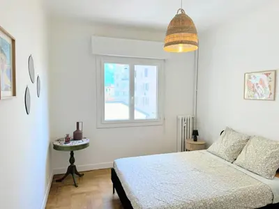 a white bedroom with a bed and a window at Charmant appartement avec balcon, près de la plage et Promenade des Anglais in Nice