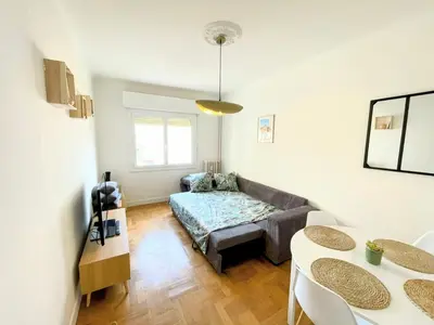 a living room with a couch and a table at Charmant appartement avec balcon, près de la plage et Promenade des Anglais in Nice
