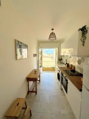 a kitchen with a table and a bench in it at Charmant appartement avec balcon, près de la plage et Promenade des Anglais in Nice