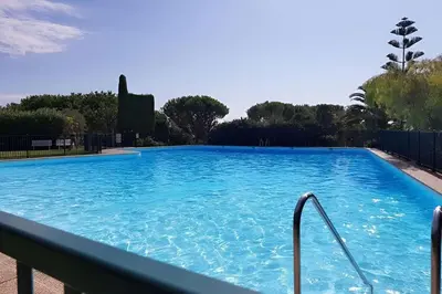 a large swimming pool with blue water at CASA-Martine vue sur mer et parking privé in Nice