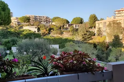 a view of a garden with flowers and buildings at CASA-Martine vue sur mer et parking privé in Nice