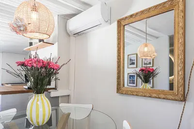 a dining room with a mirror and a glass table at Le Collet - appt climatisé proche plage in Nice
