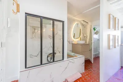 a bathroom with a glass shower and a sink at Le Collet - appt climatisé proche plage in Nice