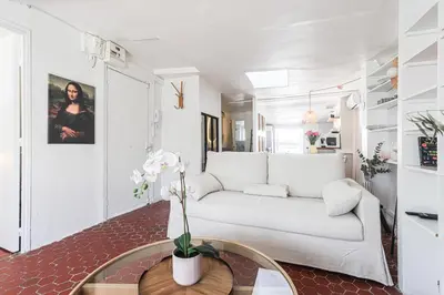 a living room with a white couch and a table at Le Collet - appt climatisé proche plage in Nice