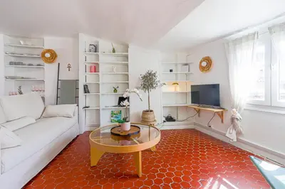 a living room with a white couch and a table at Le Collet - appt climatisé proche plage in Nice