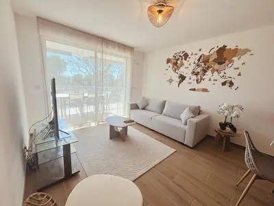 a living room with a couch and a map on the wall at L'Odyssée in Saint-Laurent-du-Var