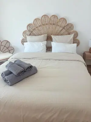 a large white bed with two towels on it at L'Odyssée in Saint-Laurent-du-Var