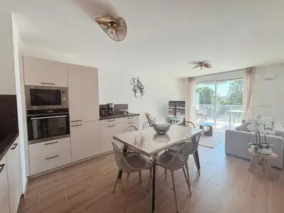 a kitchen with a table and a dining room at L'Odyssée in Saint-Laurent-du-Var