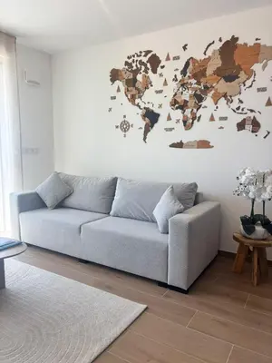 a living room with a couch and a world map on the wall at L'Odyssée in Saint-Laurent-du-Var
